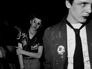Punk Fashion - Two males in graffitied tops, home made badges, make-up, ties and padlock and chain necklace. Photo Credit?